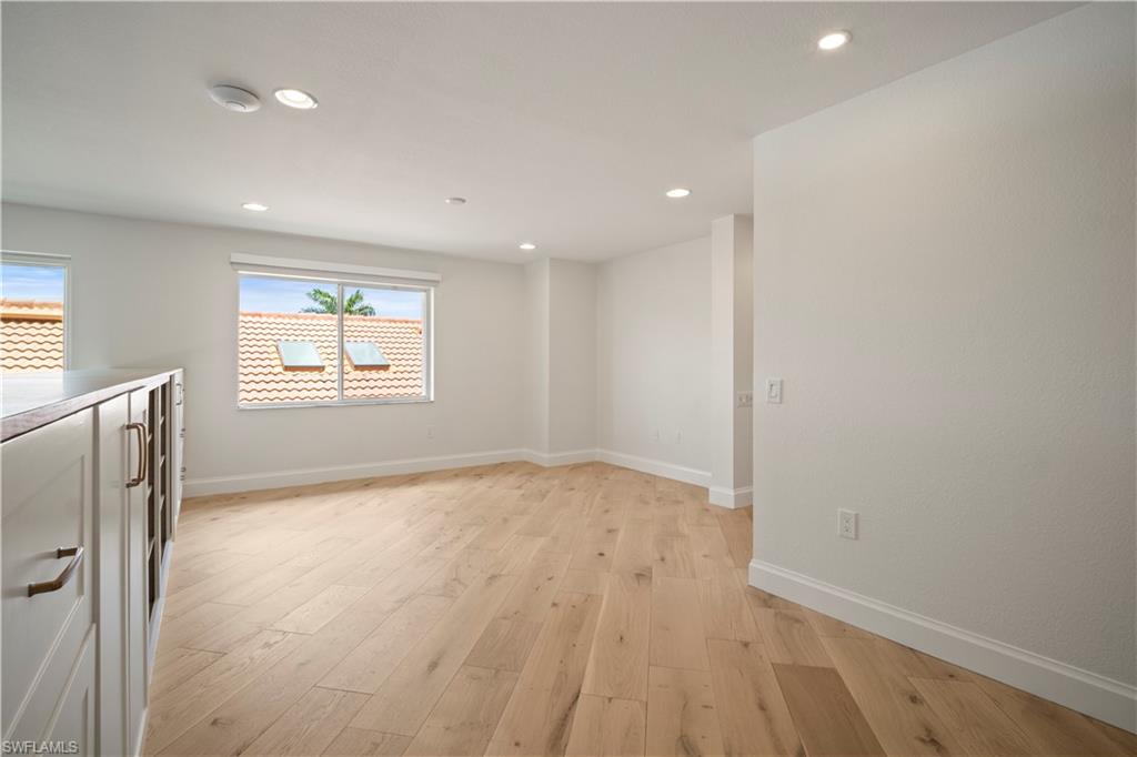 11448 Quail Village Way Naples, FL 34119 - Photo 34 of 41 an empty room with wooden floor and windows