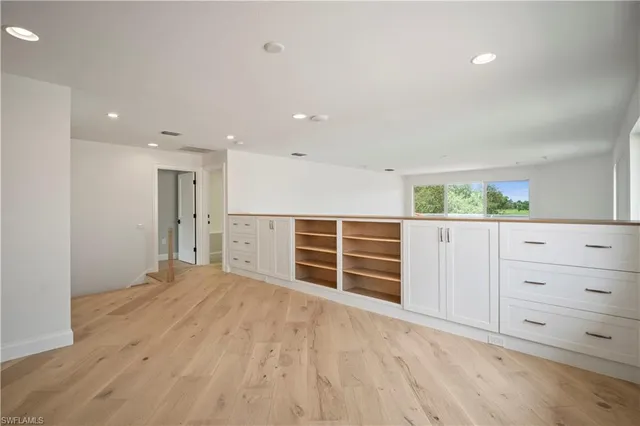 a view of an empty room with closet and wooden floor