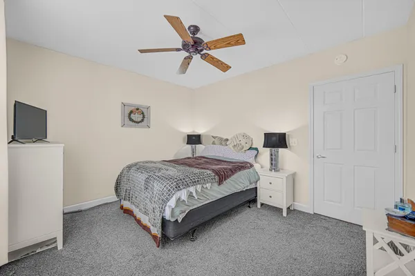 a bedroom with a bed and a ceiling fan