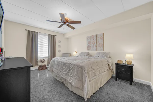 a spacious bedroom with a bed and a chandelier
