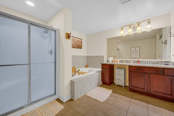 a spacious bathroom with a tub sink and mirror
