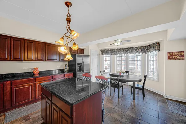 a kitchen with stainless steel appliances granite countertop a sink dishwasher and a dining table with wooden cabinet