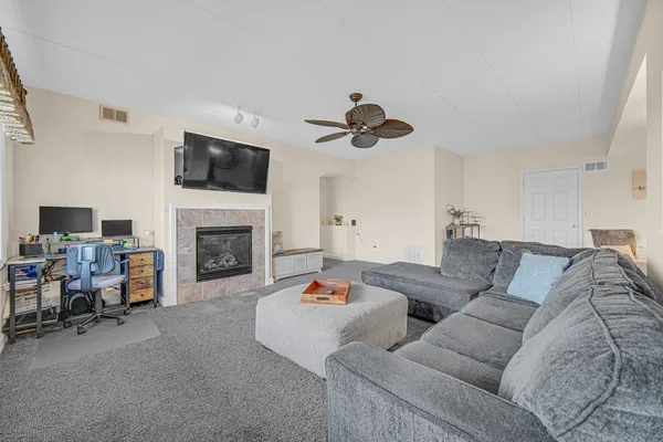 a living room with furniture a fireplace and a flat screen tv