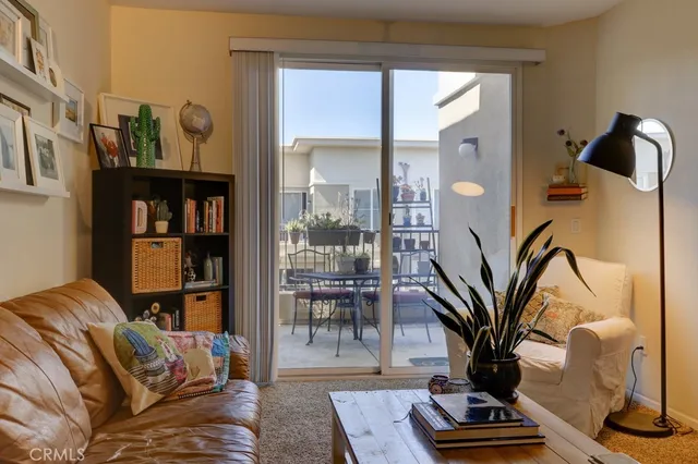 a living room with furniture a bookshelf and a large window