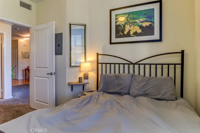 a bed room with a bed and a painting on the wall