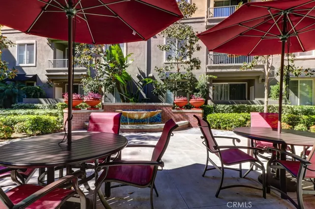 a view of a table and chairs under an umbrella in patio of a house