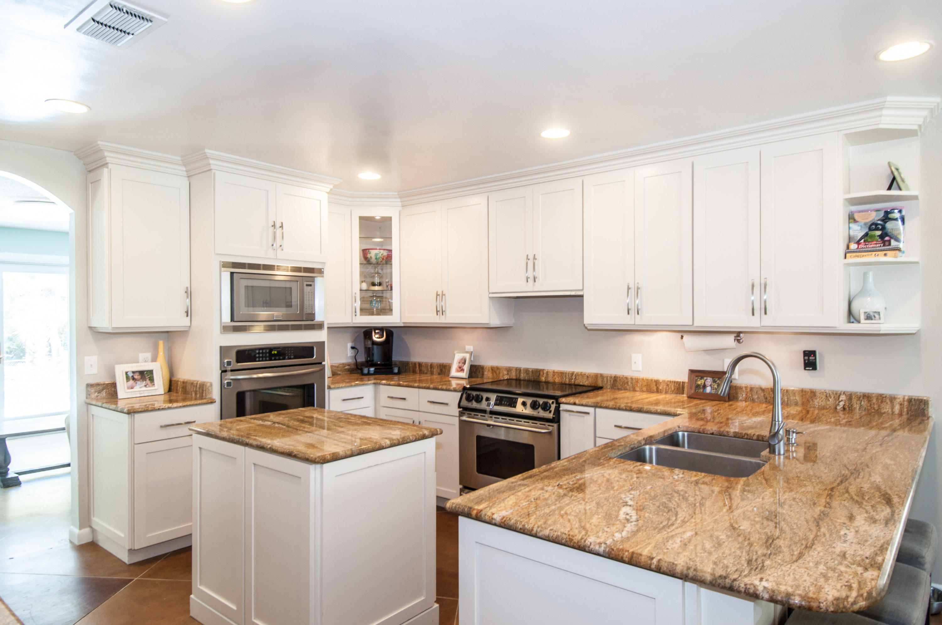 255 Ridge Lake Road Crestview, FL 32536 - Photo 27 of 54 a kitchen with kitchen island granite countertop a sink a counter top space appliances and cabinets