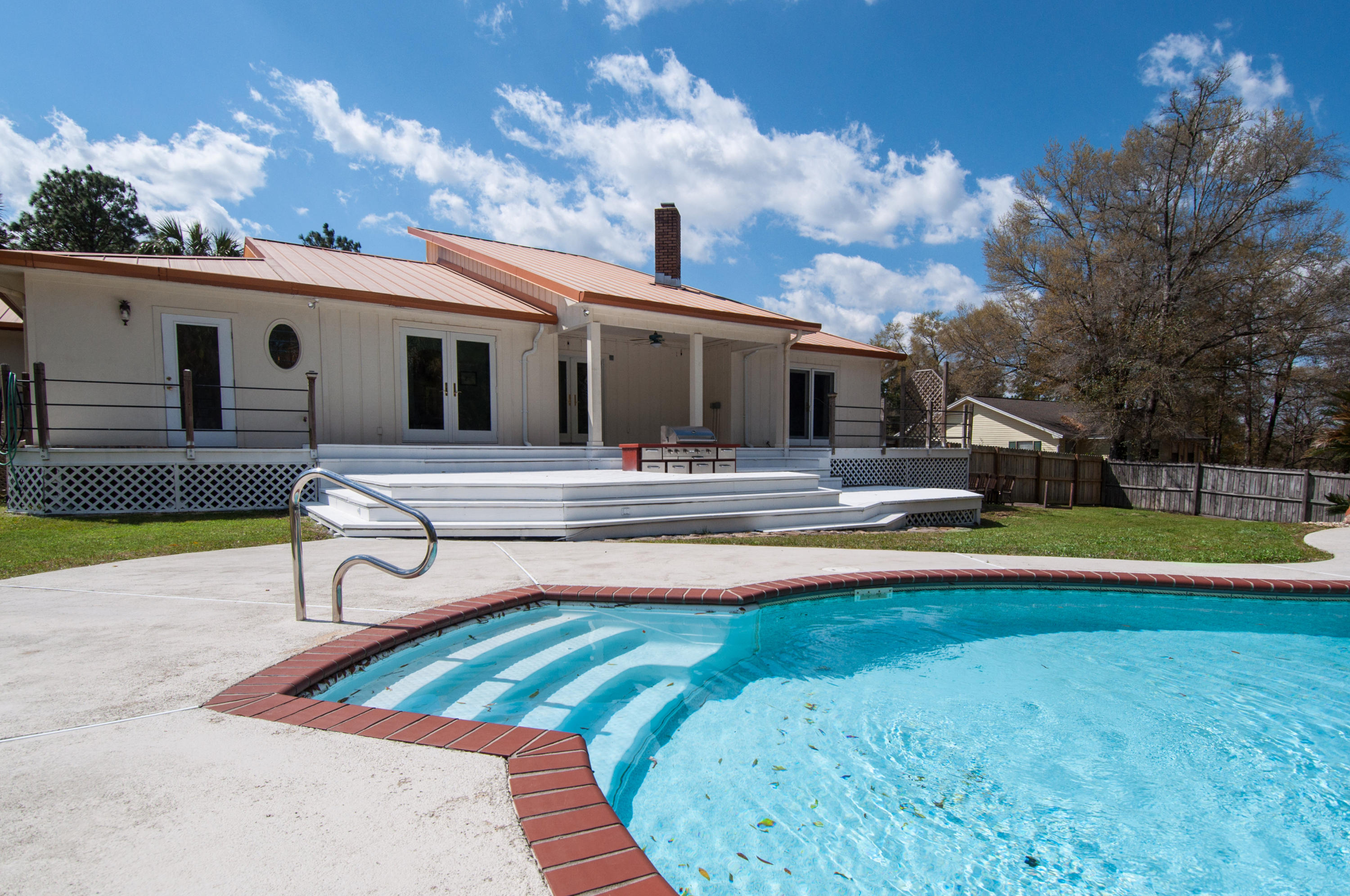 255 Ridge Lake Road Crestview, FL 32536 - Photo 7 of 54 a view of pool with lawn chairs and large trees