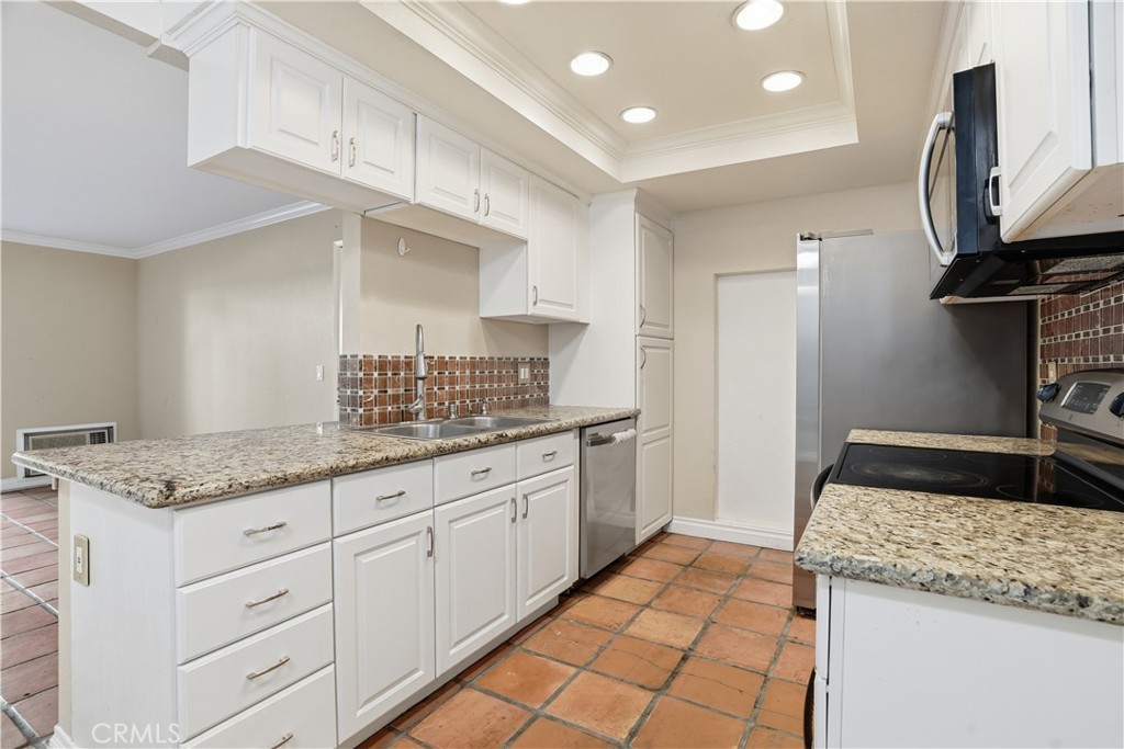 20702 El Toro Road, Unit 231 Lake Forest, CA 92630 - Photo 20 of 36 a kitchen with granite countertop a sink and a stove