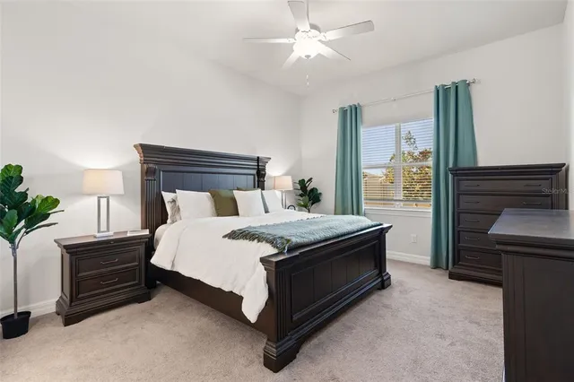 a bed sitting in a room next to a window and a chandelier