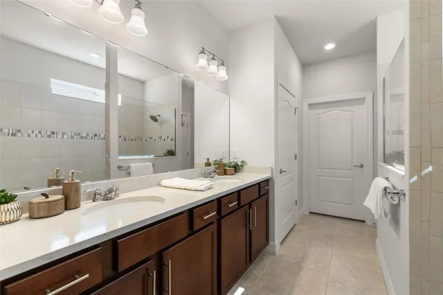 a spacious bathroom with a double vanity sink a mirror and a shower
