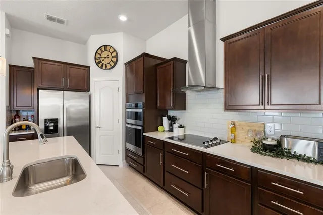 a kitchen with stainless steel appliances granite countertop a refrigerator and a sink