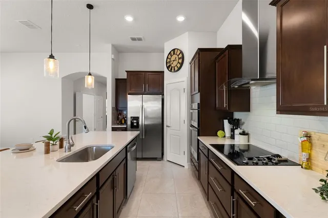 a kitchen with stainless steel appliances a sink stove and refrigerator