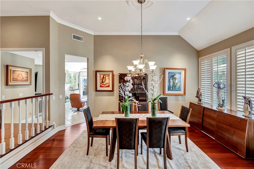 6096 Eaglecrest Drive Huntington Beach, CA 92648 - Photo 15 of 64 a view of a dining room with furniture a chandelier and wooden floor