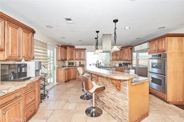 a kitchen with stainless steel appliances kitchen island granite countertop a sink a counter top space cabinets and stainless steel appliances