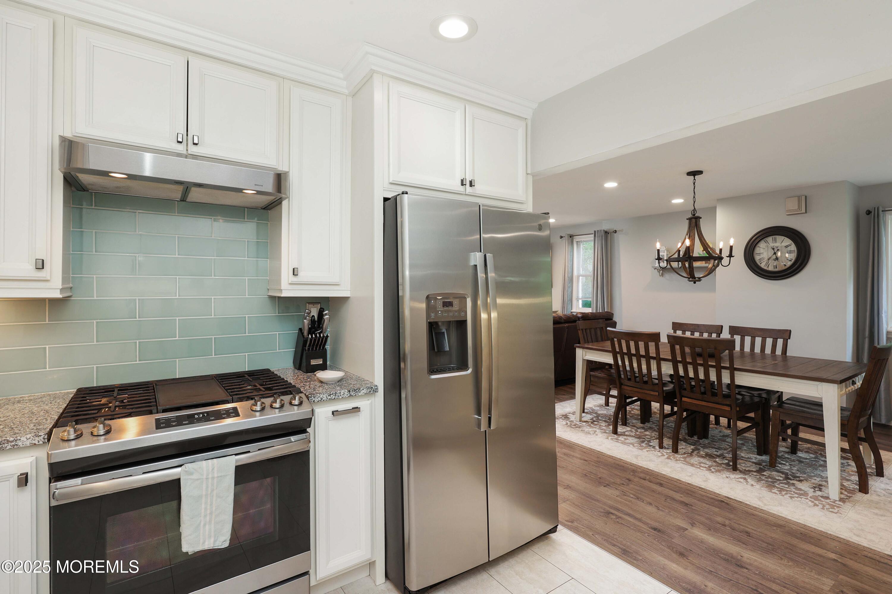 29 Lake Boulevard Matawan, NJ 07747 - Photo 13 of 39 a kitchen with stainless steel appliances granite countertop a refrigerator a stove and a sink with wooden floor