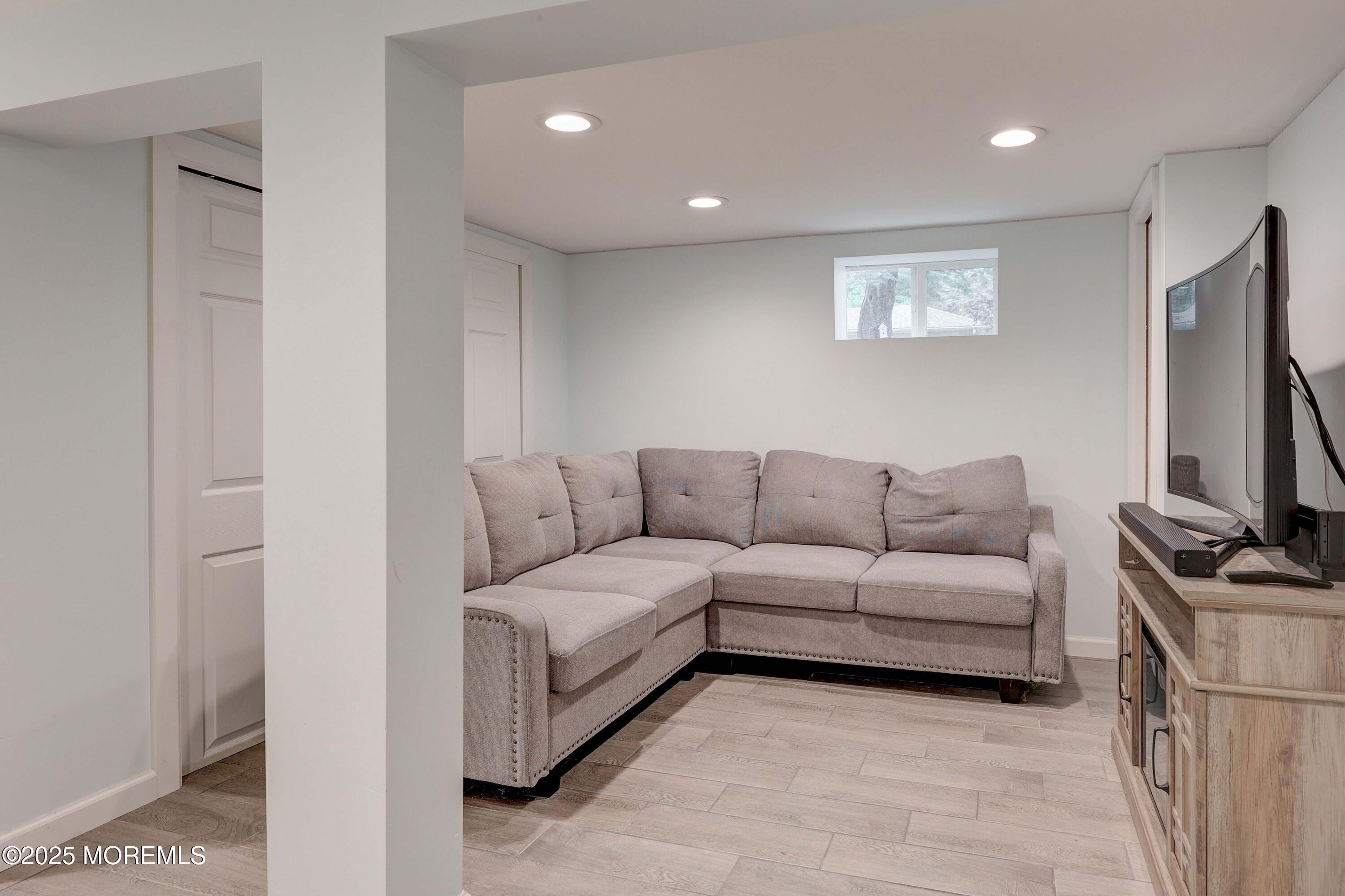 29 Lake Boulevard Matawan, NJ 07747 - Photo 24 of 39 a living room with furniture a flat screen tv and a refrigerator