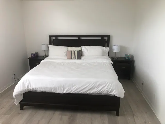 a large bed sitting in a bedroom next to a window