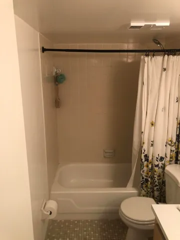 a bathroom with a toilet and a shower