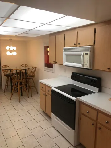 a kitchen with cabinets and chairs