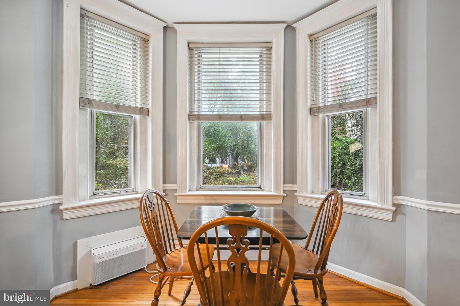 1831 Belmont Road Northwest, Unit 201 Washington, DC 20009 - Photo 5 of 11 a view of a dining room with furniture large windows and wooden floor