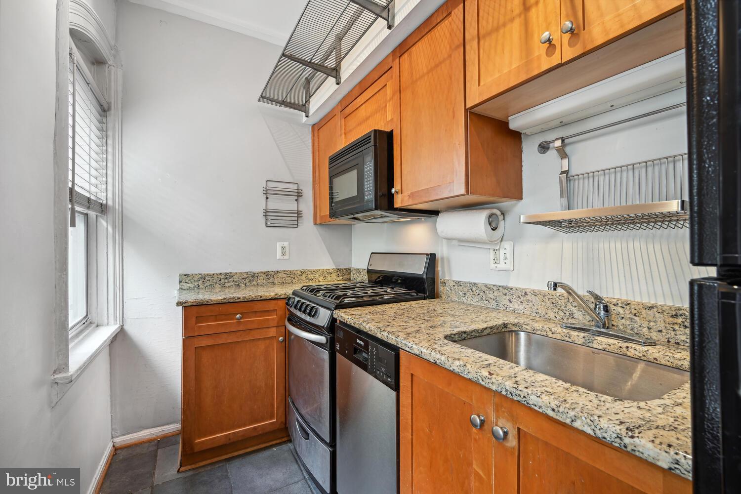 1831 Belmont Road Northwest, Unit 201 Washington, DC 20009 - Photo 7 of 11 a kitchen with stainless steel appliances granite countertop a sink stove and refrigerator