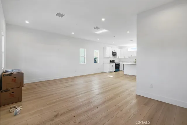 a view of empty room with wooden floor