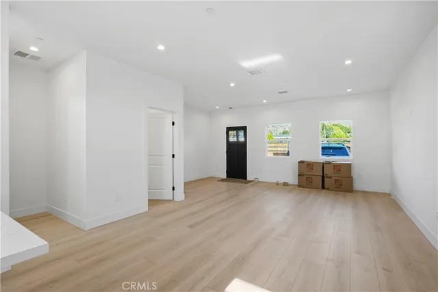 an empty room with kitchen wooden floor and windows