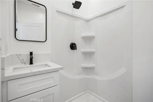 a bathroom with a sink vanity and mirror