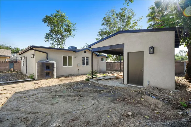 a view of a house with backyard and trees in the background