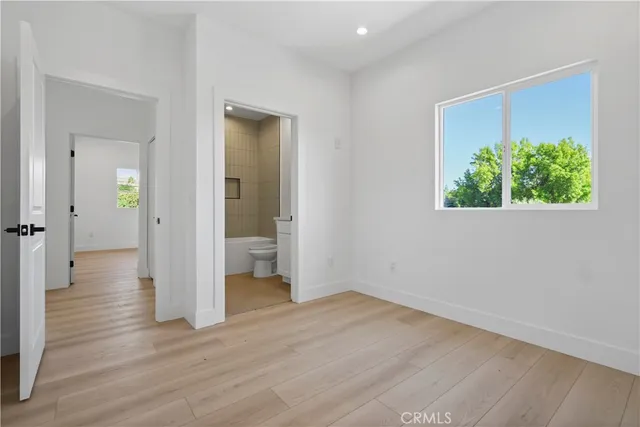 a view of a hallway with wooden floor and a room