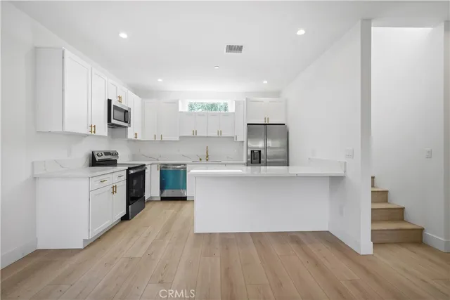 a kitchen with a sink cabinets and wooden floor