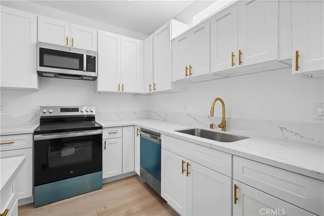 a kitchen with cabinets stainless steel appliances a sink and cabinets