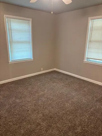 an empty room with windows and closet