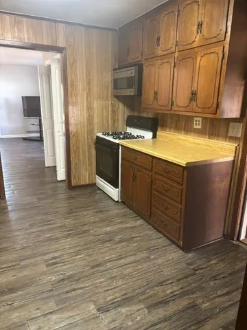 a kitchen with stainless steel appliances granite countertop a sink counter space cabinets and wooden floor