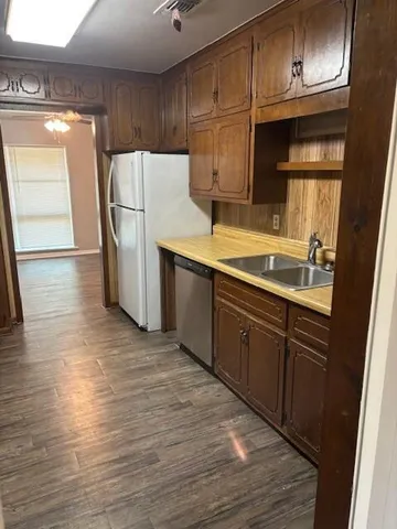 a kitchen with a sink a refrigerator and cabinets