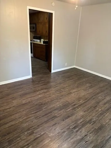 a kitchen view with wooden floor and a refrigerator
