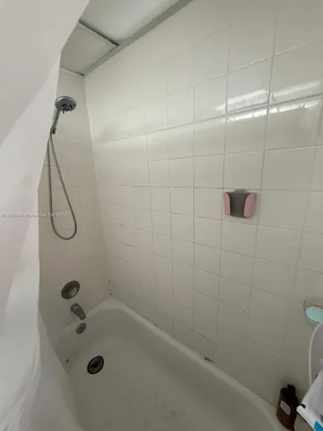 a bathroom with a bath tub with a shower