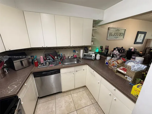 a kitchen with stainless steel appliances granite countertop a sink dishwasher stove and cabinets