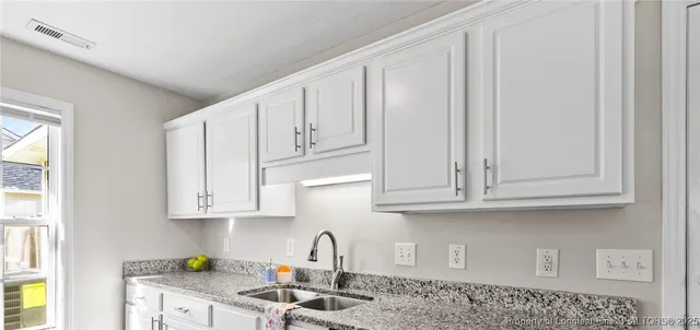a kitchen with white cabinets and a sink