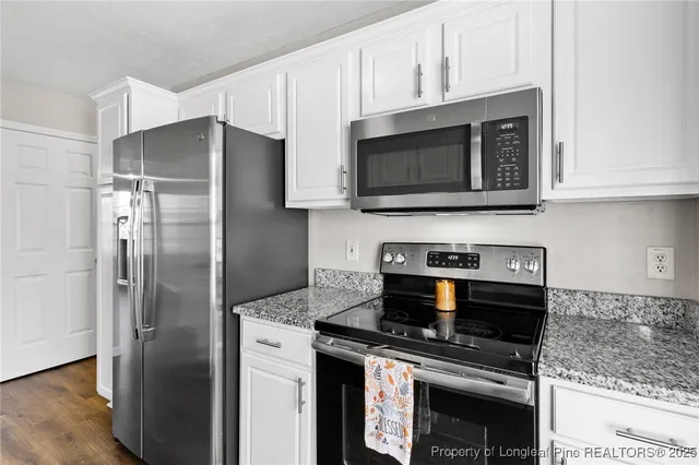 a kitchen with stainless steel appliances granite countertop a stove microwave and refrigerator