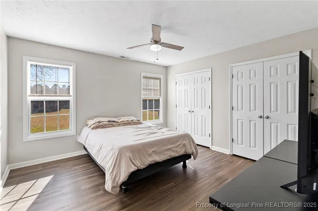 a bed sitting in a spacious bedroom next to a window