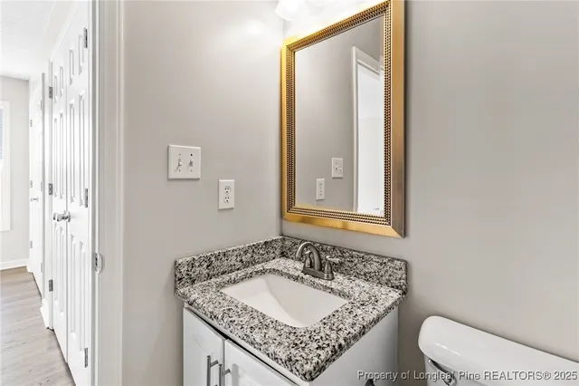 a bathroom with a granite countertop sink and a mirror