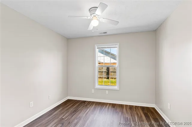 an empty room with a window and wooden floor