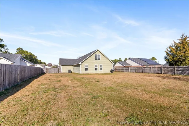 a view of a large house with a big yard and large trees