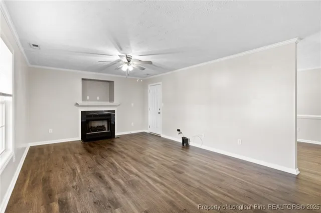 a view of an empty room with a fireplace and a window
