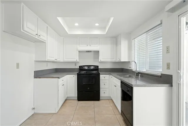 a kitchen with granite countertop white cabinets and white appliances