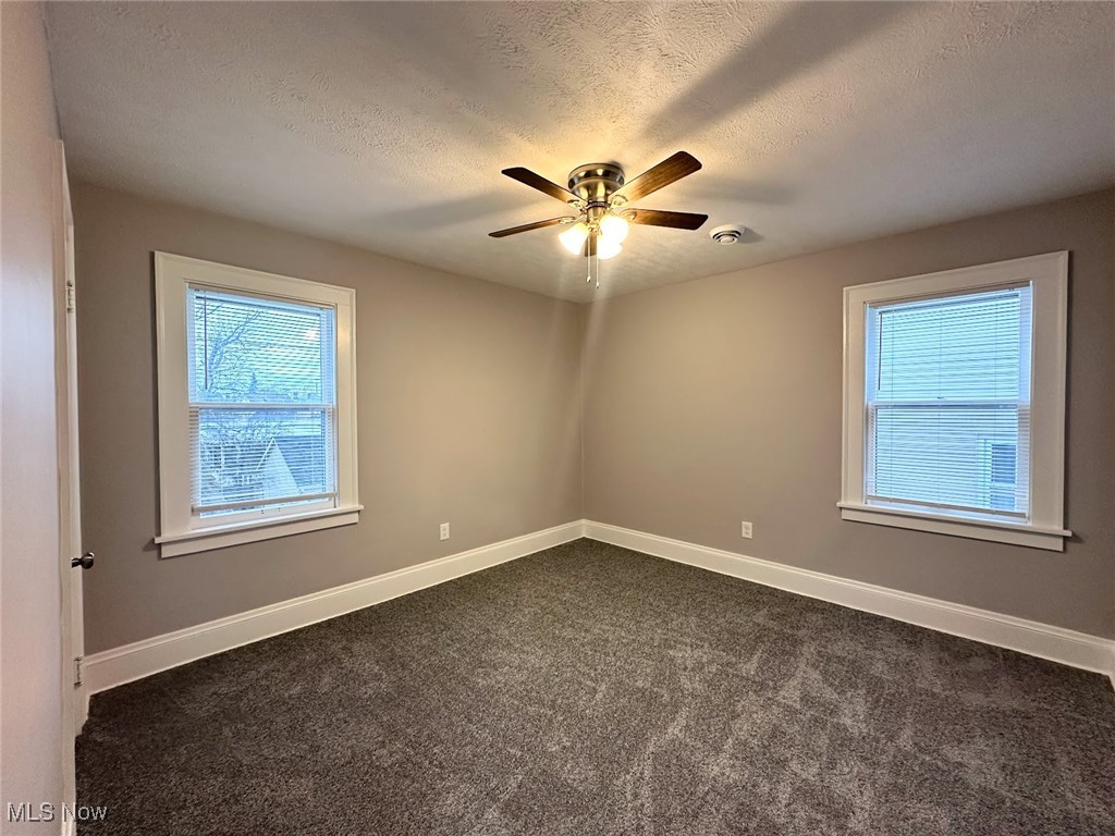 3393 Kildare Road Cleveland, OH 44118 - Photo 8 of 15 Spare room with dark colored carpet, ceiling fan, and a textured ceiling
