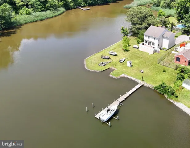 an aerial view of a house with a yard and lake view