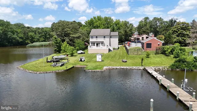 a kitchen with stainless steel appliances granite countertop a refrigerator a stove top oven a sink dishwasher and white cabinets with wooden floor